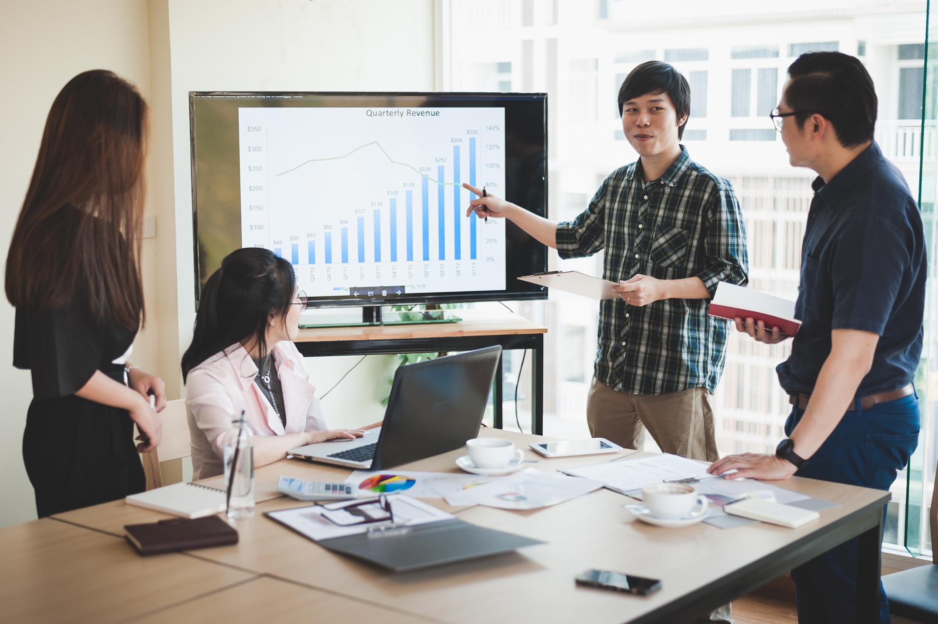 Team präsentiert Diagramm zur Kostenanalyse im Meeting | externe Lohnbuchhaltung